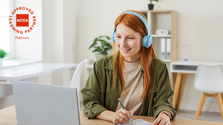 woman with headphones, working on laptop