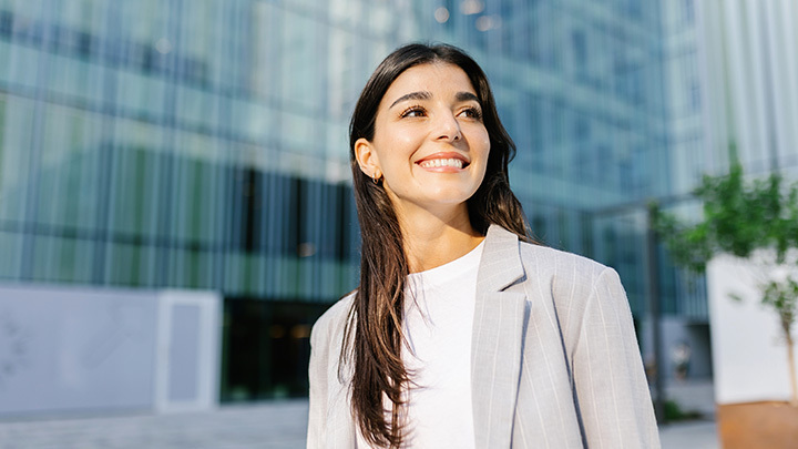 A professional woman walking in a work environment where she is focusing on building a flexible career path