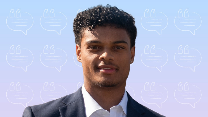 Headshot of a young man with short curly black hair, wearing a suit jacket and white collared shirt, against a light blue gradient background patterned with quote-bubble icons.