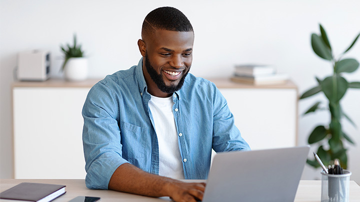 Man working on a laptop smiling