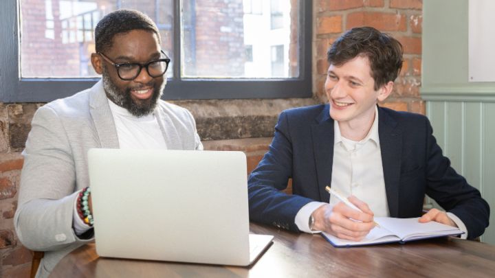 Two men looking at a laptop