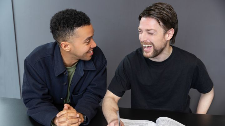 Two men at a desk laughing