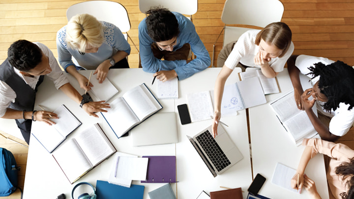 Looking down on office table with people working