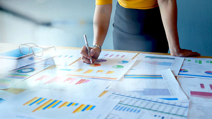 Person writing on a large data sheet