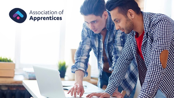Two man standing and working at laptop. Association of Apprentices logo in top corner