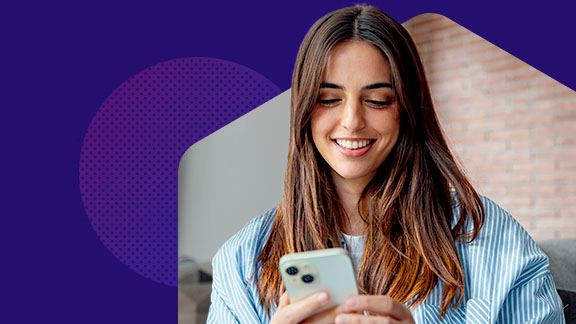 A woman looking at a mobile phone in her hand.