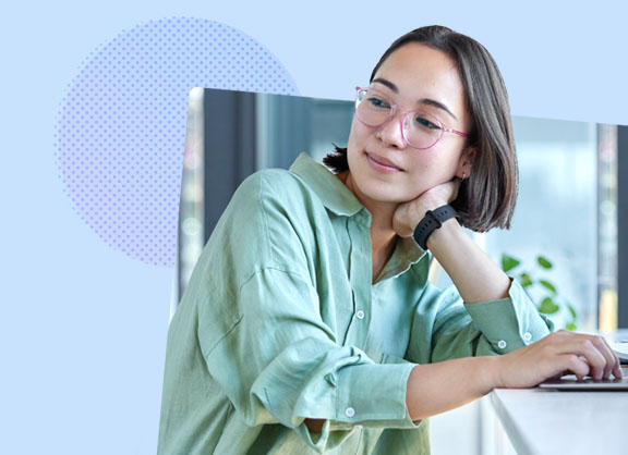 A woman with one hand on a laptop and leaning her face on the other hand.