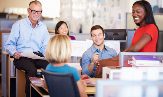 Three men and two women talking in an office