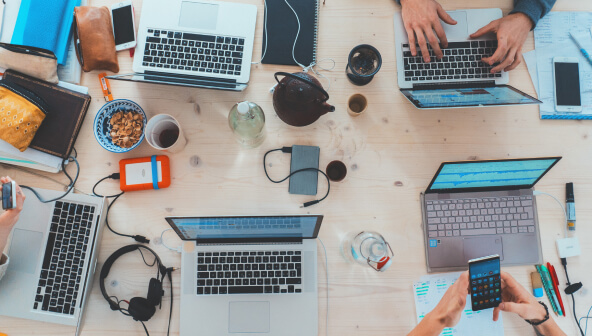 People working at a desk using laptops