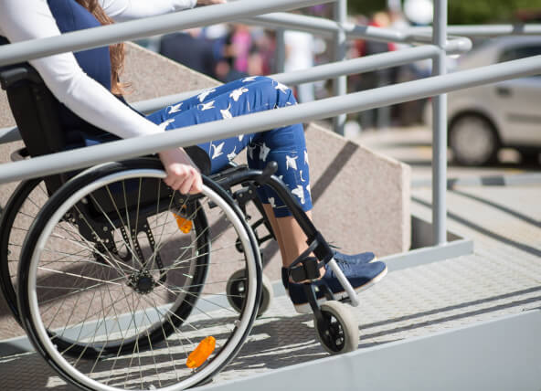 A woman in a wheelchair going up a ramp