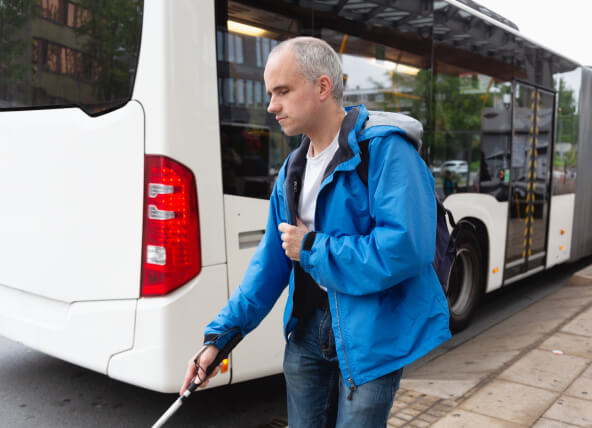A man with a sight impairment walking with a white cane