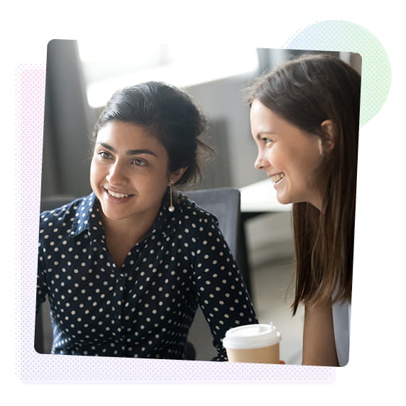 Two women looking at a computer screen and smiling