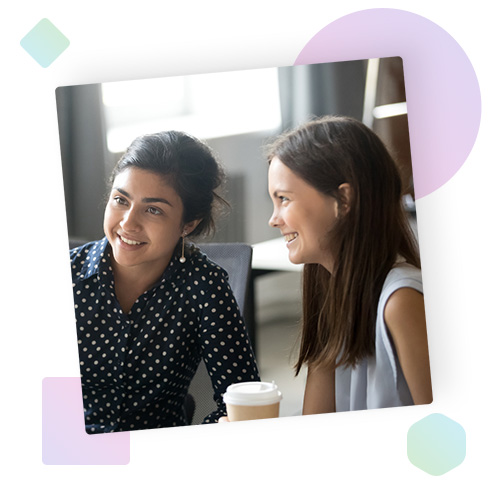 Two women looking at a monitor and smiling