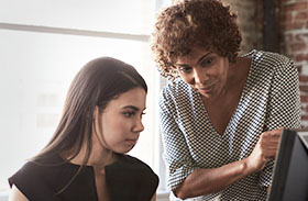 Two women looking at a computer screen