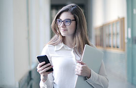 A woman holding a mobile phone and a folder