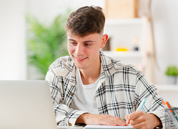 Man smiles at computer when studying