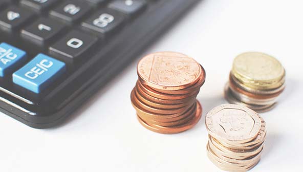 A calculator and three piles of coins