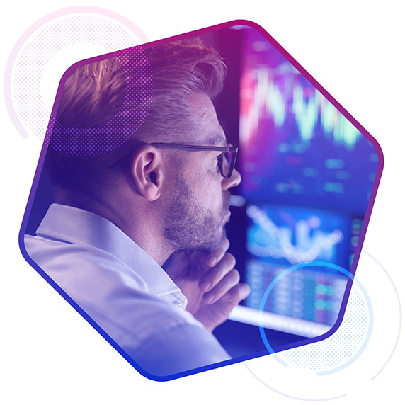 A man wearing glasses looking at a screen with data graphics
