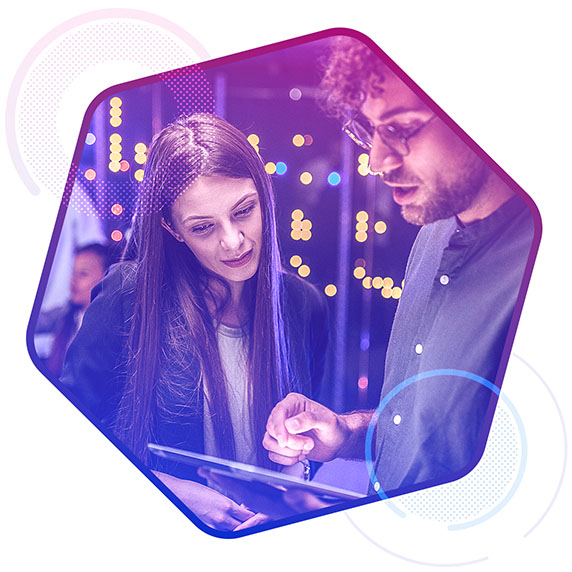 A woman and a man looking down at a computer tablet