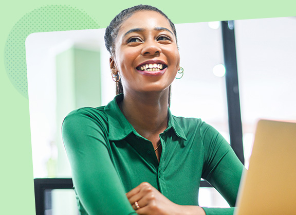 Smiling woman sat down in front of a laptop