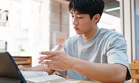 Man holding a pen and reading a book