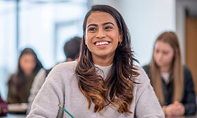 Woman smiling holding a pen