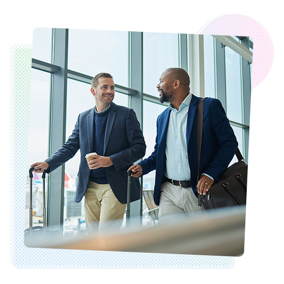 Two men walking through an airport with suitcases