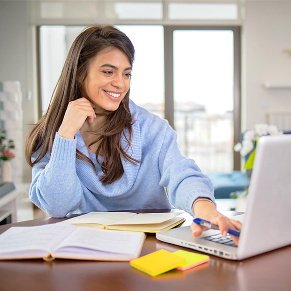 A woman looking at a laptop.