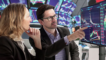 A man pointing at a screen showing demonstrating something to a woman