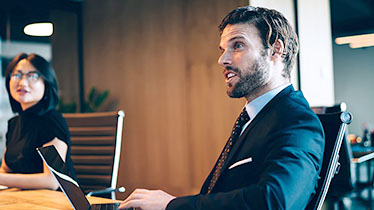 A man sat at a desk with a laptop
