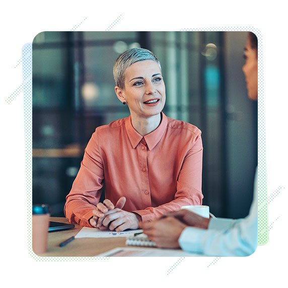 A woman in a meeting sat at a desk 