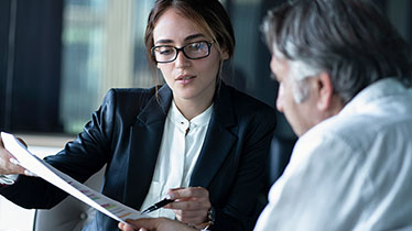 Woman describing a document to a colleague
