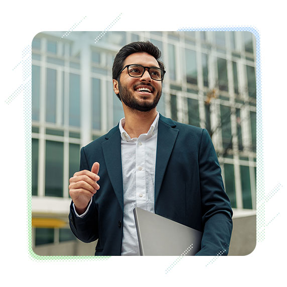 Man in suit smiling holding laptop