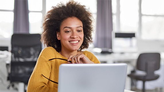 Woman smiling and looking at a laptop screen