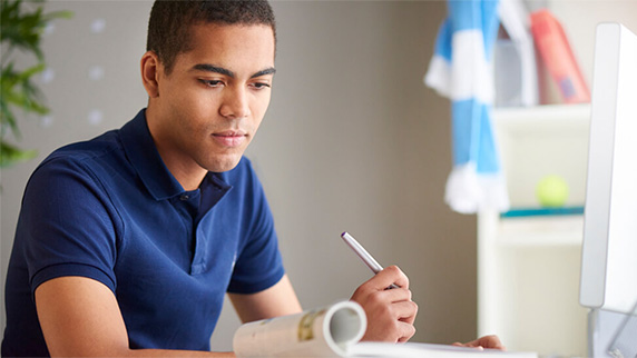 Man holding a pen and reading a book