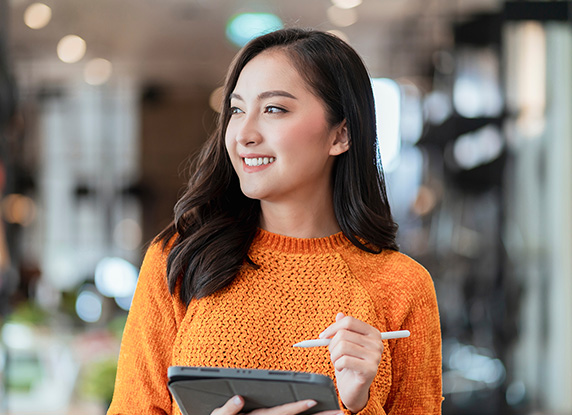 A woman holding a tablet and tablet pen.