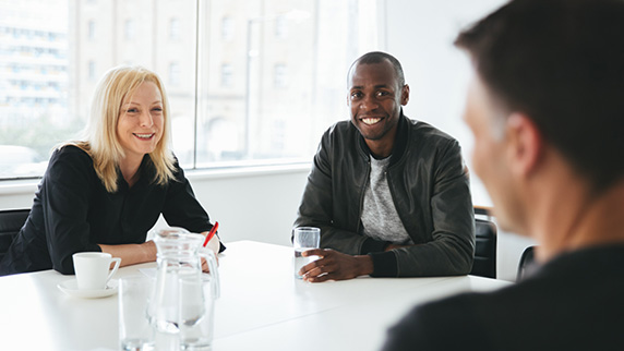 Man talking to another man and woman