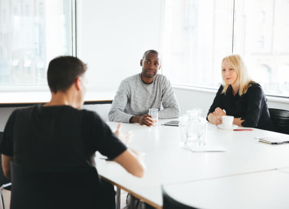 A man and a lady listening to a man speaking