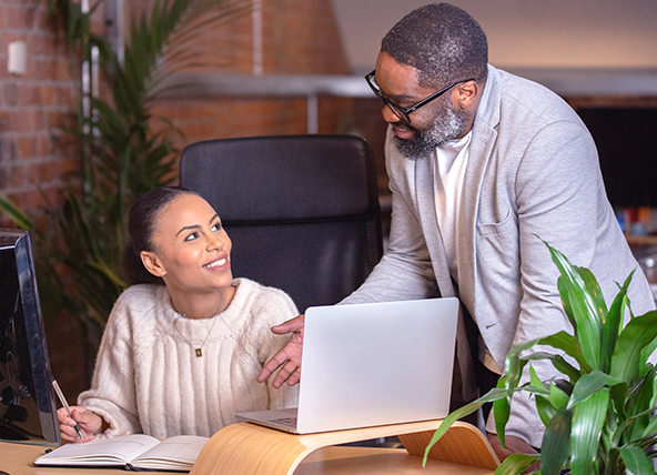 A man talking to a woman sat at a desk