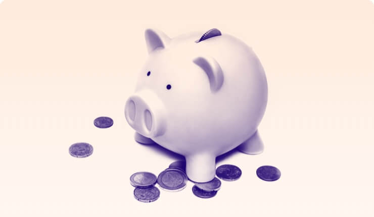 A piggy bank with a few coins surrounding it