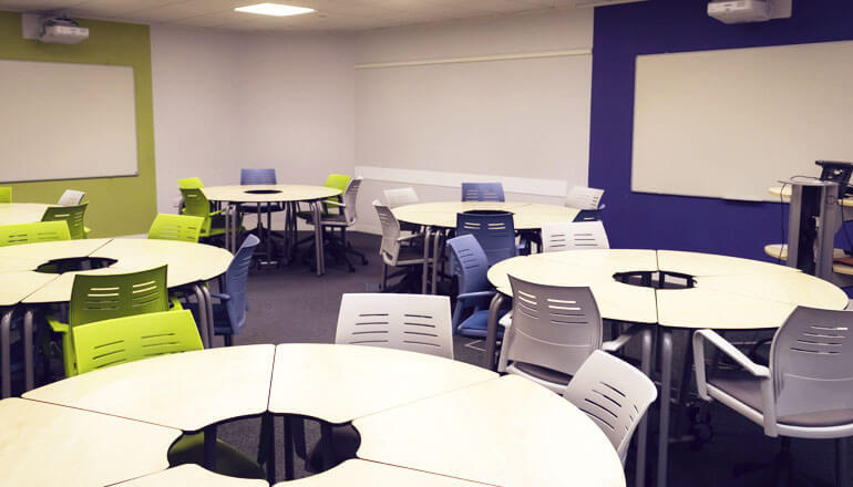 Tables, chairs and interactive whiteboards in a Kaplan Manchester centre classroom