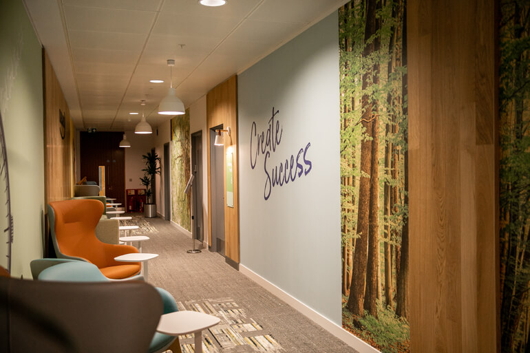 Corridor with nice seating areas and a woodland scene on the wall