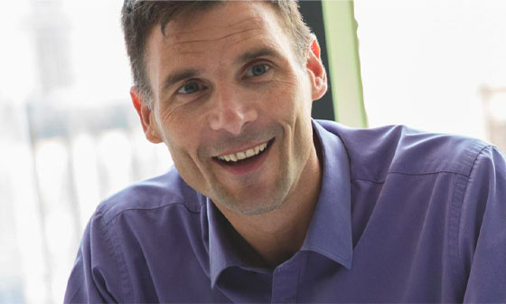 A man in purple shirt smiling