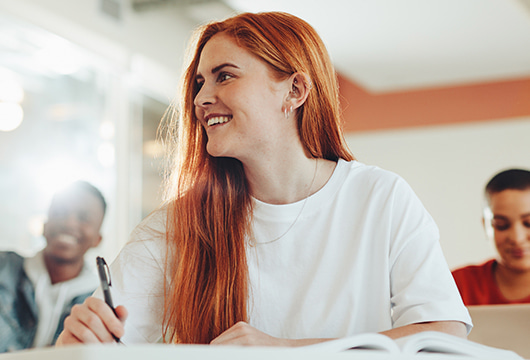 A woman sitting at a table writing