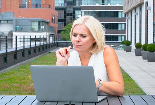 A woman sitting outside using a laptop