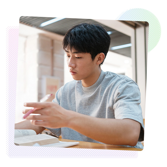 Man holding a pen flicking through a book