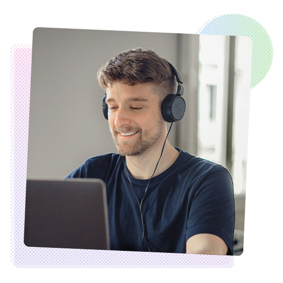 Man wearing headphones looking at a laptop screen.