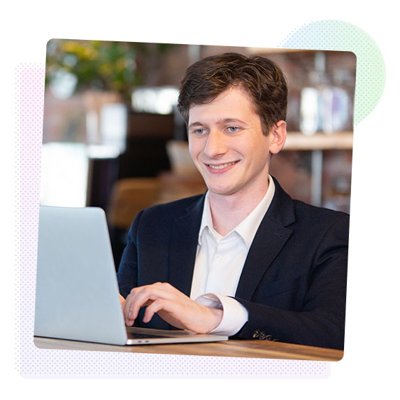 Man smiling working on a laptop