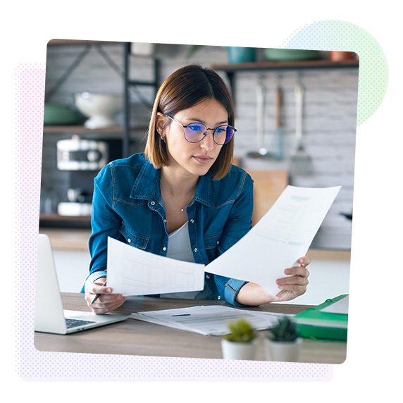 Woman sat at a desk looking at sheets of paper