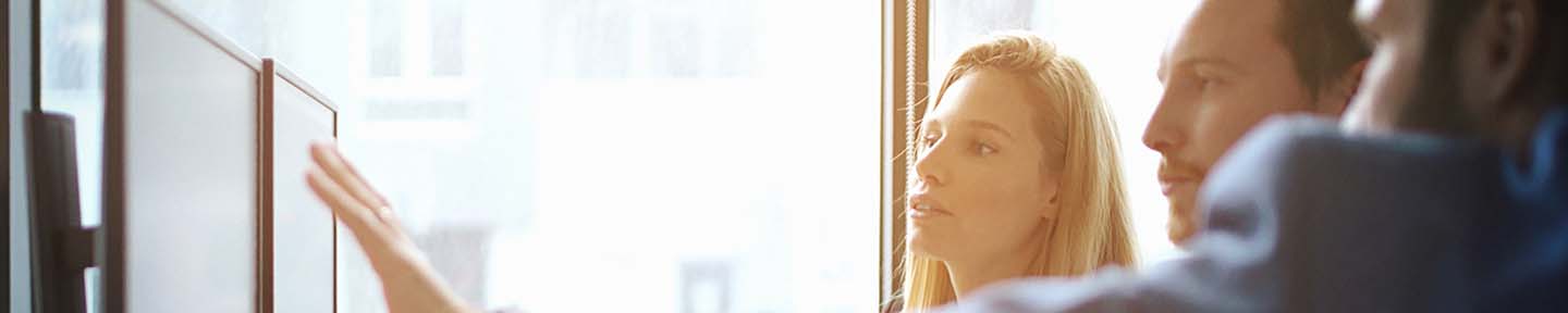 A man explaining something to a man and a woman